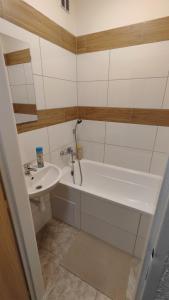 Un baño con bañera blanca y lavabo. en Apartmán pro 4 osoby Pohraniční stráže, Kraslice, en Kraslice
