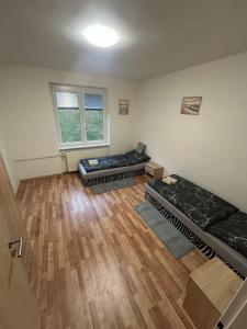 Habitación con 2 camas y suelo de madera. en Apartmán pro 4 osoby Pohraniční stráže, Kraslice, en Kraslice 10 fotos más