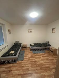 Tres camas en una habitación con suelo de madera. en Apartmán pro 4 osoby Pohraniční stráže, Kraslice, en Kraslice