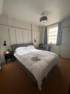 a bedroom with a white bed and a window at The Thirsty Scholar in Penryn