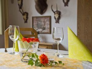 a table with wine glasses and flowers on it at Hotel Walkenstein in Oberwolfach +44 photos