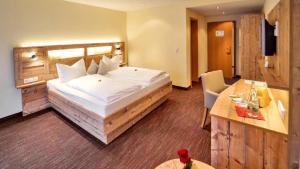 a hotel room with a large bed and a table at Hotel Walkenstein in Oberwolfach
