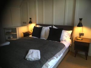 a bedroom with a large bed with a white towel on it at The Thirsty Scholar in Penryn