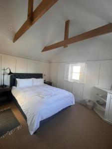 a bedroom with a large white bed with a ceiling at The Thirsty Scholar in Penryn +2 photos