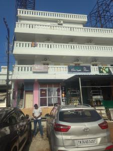 KuilapayamにあるOcean luxe innの建物の前に立っている男性