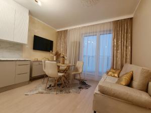 a living room with a couch and a table at Apartament Osiedle Piano Park Suwałki in Suwałki
