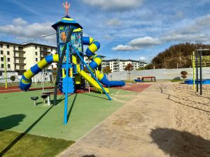 a playground with a slide in a park at Apartament Osiedle Piano Park Suwałki in Suwałki