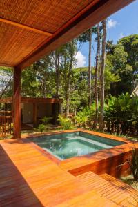 a swimming pool in a house with a wooden deck at casa refugio das bromelhas in Itacaré