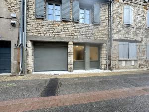 a brick building with a garage door on a street at Les Vignes 3 Chambres avec Salle de bain privative in Anse