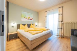 Un dormitorio con una cama con almohadas amarillas. en Appartements Sigmair, en Valdaora