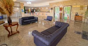 a living room with a leather couch and a table at Hotel Dan Inn Campinas Anhanguera - By Nacional Inn in Campinas +81 photos