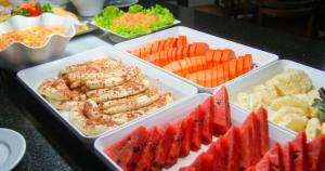 a buffet with trays of food and fruits and vegetables at Hotel Dan Inn Campinas Anhanguera - By Nacional Inn in Campinas