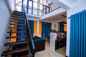 a staircase leading to a living room with colorful curtains at Sunny Hill Villa in Mirissa