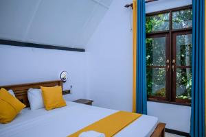 a bedroom with a bed with yellow pillows and a window at Sunny Hill Villa in Mirissa +110 photos