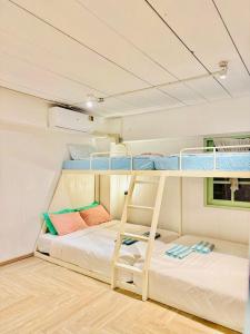 two bunk beds in a room with a ladder at The Green Khaosan Bangkok in Bangkok