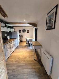 Le Dahlia - Jardin de Marie في Cerizay: مطبخ مع طاولة وغرفة طعام