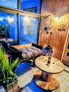 Le Dahlia - Jardin de Marie في Cerizay: غرفة مع طاولة و أريكة و طاولة و طاولة