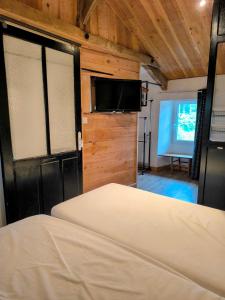 Le Dahlia - Jardin de Marie في Cerizay: غرفة نوم مع سرير وتلفزيون بشاشة مسطحة