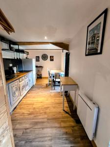 Le Dahlia - Jardin de Marie في Cerizay: مطبخ مع طاولة وغرفة طعام