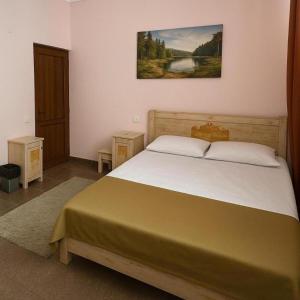 a bedroom with a bed and a painting on the wall at Americana By California in Yerevan