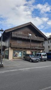 a building with two cars parked in front of it at San Rocco Lodge in Livigno