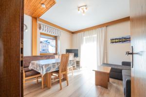 comedor y sala de estar con mesa y sofá en Appartements Sigmair, en Valdaora