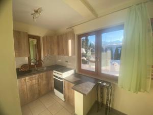een keuken met een groot raam en een wastafel bij Kapacówka in Zakopane