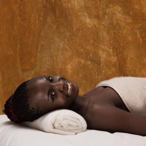 a woman laying on a bed with a towel at DOMO By Design Union in Lagos