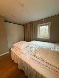 a large bed in a room with a window at Mysig stuga Buared - Family nature stay in Varberg