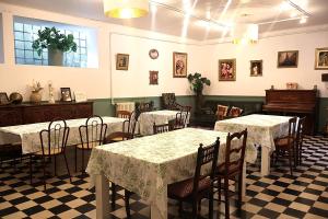 a restaurant with tables and chairs and a piano at La Roseraie in Lodève