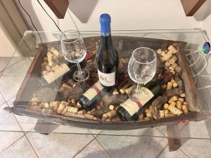 B&B Ginepro blu في بورتوسكوسو: صينية مع زجاجتين من النبيذ وكأسين +23 صورة