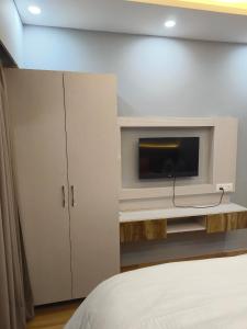 a bedroom with a flat screen tv and a bed at Anantya Inn in Greater Noida +4 photos