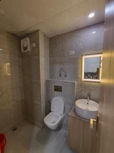 a bathroom with a toilet and a sink at Anantya Inn in Greater Noida