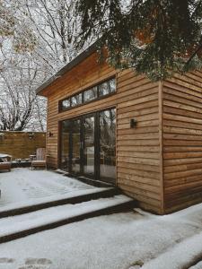 a wooden house with glass doors in the snow at The Lodge Burniston in Scarborough