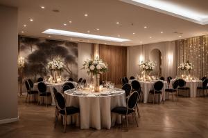 Una sala de conferencias con mesas, sillas y flores. en Hotel HP Tower One Brasov, en Brasov