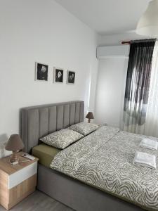 a bedroom with a bed and a table with a night stand at Apartment Center Korça in Korçë