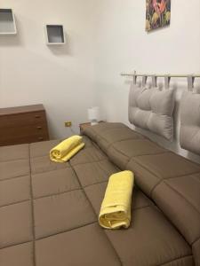 a room with a bed with two yellow blankets at Tower casa vacanze 1 in Anzio