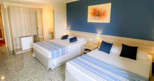 a hotel room with two beds with blue walls at Hotel Dan Inn Campinas Anhanguera - By Nacional Inn in Campinas
