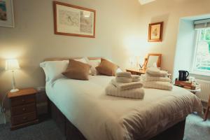 The Falcon Inn في Saint Mawgan: غرفة نوم بها سرير مع مناشف عليه