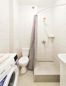 Un baño blanco con inodoro y ducha. en Радужная студия Вокзал Харьков-Пассажирский, en Járkov