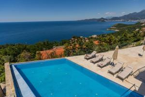 a swimming pool with a view of the ocean at Olive Resort in Petrovac na Moru