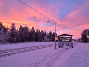 a sign on the side of a road in the snow at Kaamasen Kievari in Kaamanen