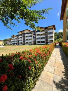 a large apartment building with flowers in front of it at Resort Flat Gavoa in Igarassu