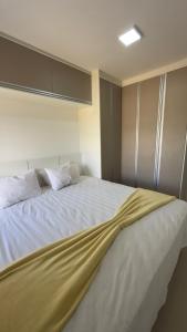 a large white bed with a yellow blanket on it at Resort Flat Gavoa in Igarassu +12 photos