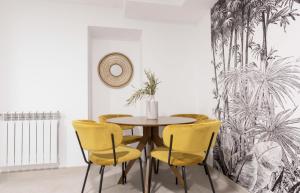 Un comedor con una mesa y sillas amarillas. en Design Apartment Disneyland Paris, en Chessy