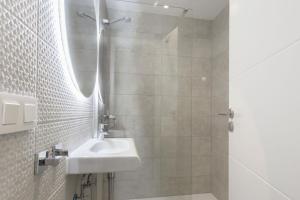 un baño con lavabo y ducha en Design Apartment Disneyland Paris, en Chessy