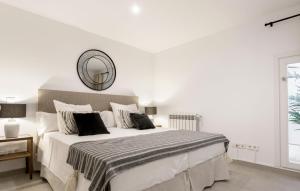 Dormitorio blanco con cama grande y espejo en Design Apartment Disneyland Paris, en Chessy