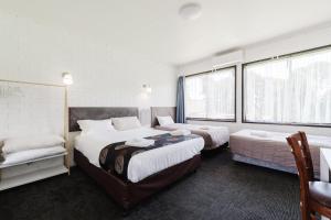 a hotel room with two beds and a window at The Reserve Hotel in Sale