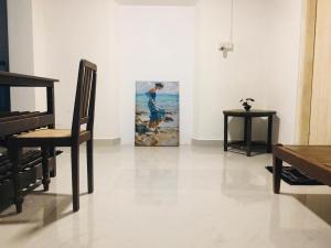 a room with a chair and a painting on the wall at Madiha Dolamulla Gedara in Kamburugamuwa