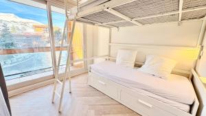 T3 Vanguard in front of ski school في Villarembert: غرفة نوم مع سرير بطابقين ونافذة
